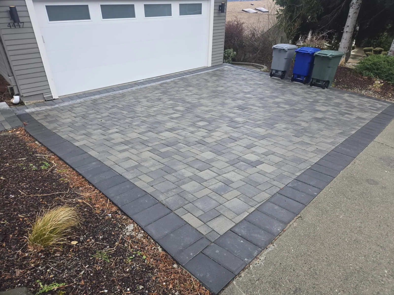 Completed gray paver driveway with charcoal border